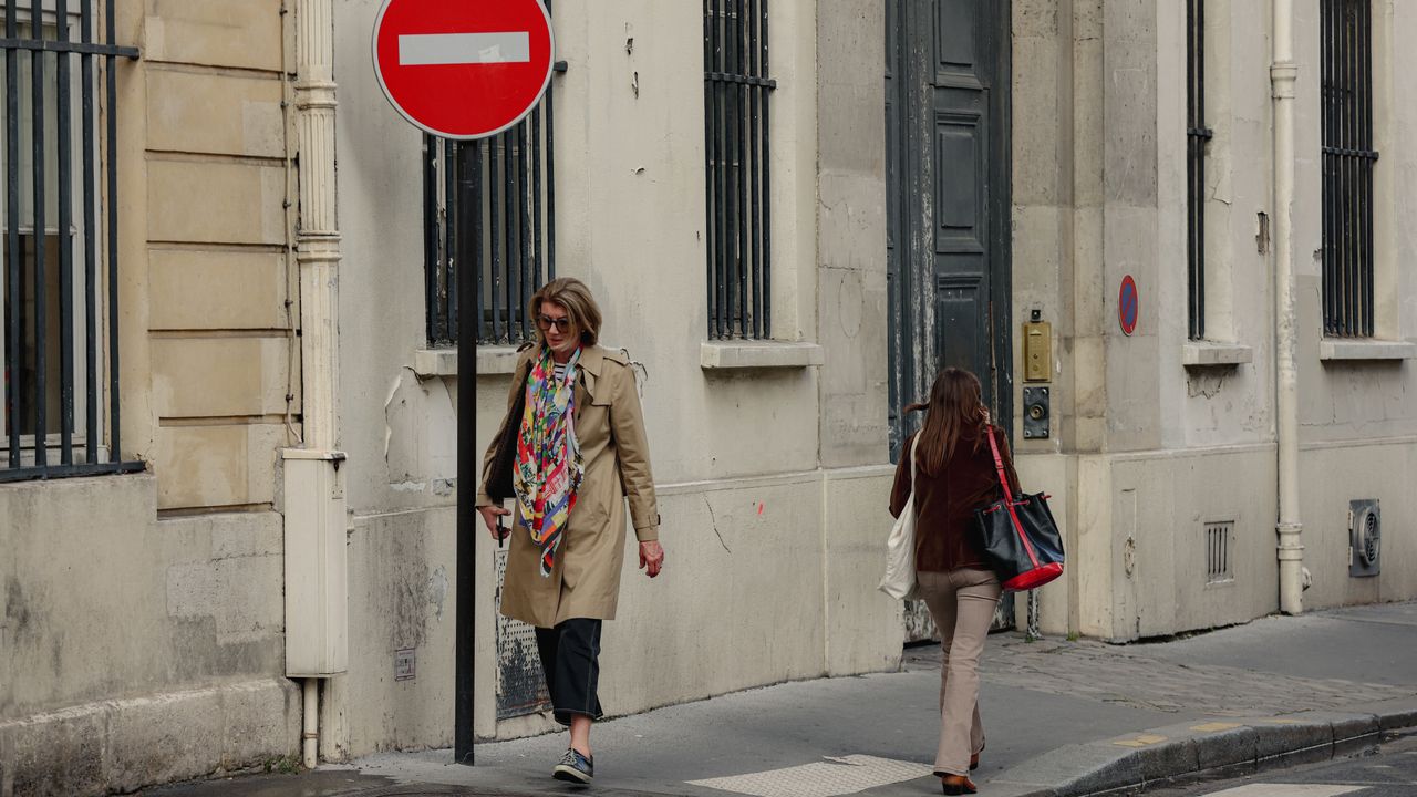 our-experience Urban street scene in Paris, Île-de-France, with two women walking and a no entry sign in view.